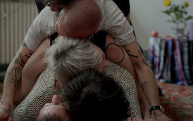 Film still from Sarnt Utamachote’s film “I Don’t Want to Be Just a Memory”. Five people lay on top of and embrace each other in the form of a cuddle puddle.