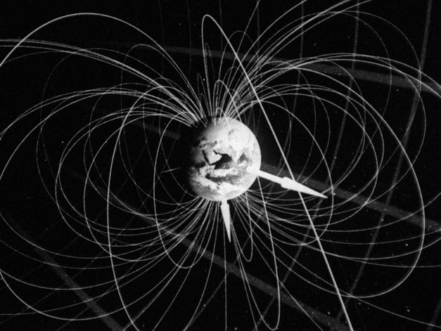 Film still from Deborah Stratman’s „Last Things“. A three-dimensional model of the earth in the centre of the picture, surrounded by its magnetic field lines and axiis.
