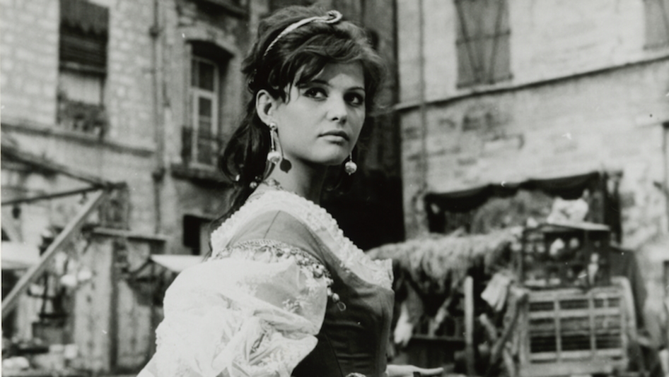 Film still from CARTOUCHE: Claudia Cardinale in a street scene in a historical costume. 