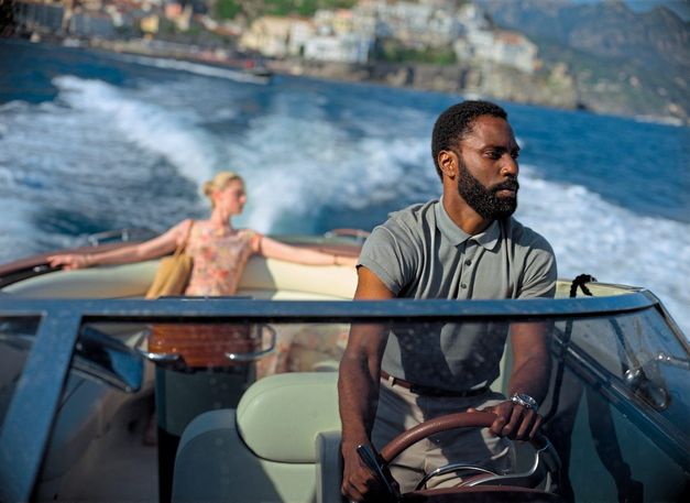 Filmstill aus TENET: Ein Mann ist am Steuer eines kleines Motorbootes, hinter ihm sitzt eine Frau.