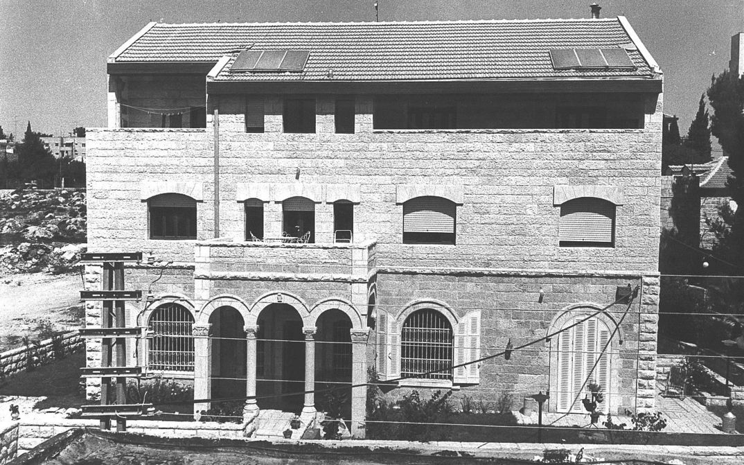 Filmstill aus HOUSE: Ein Gebäude mit drei Etagen, Balkon und Säulen im Eingangsbereich.