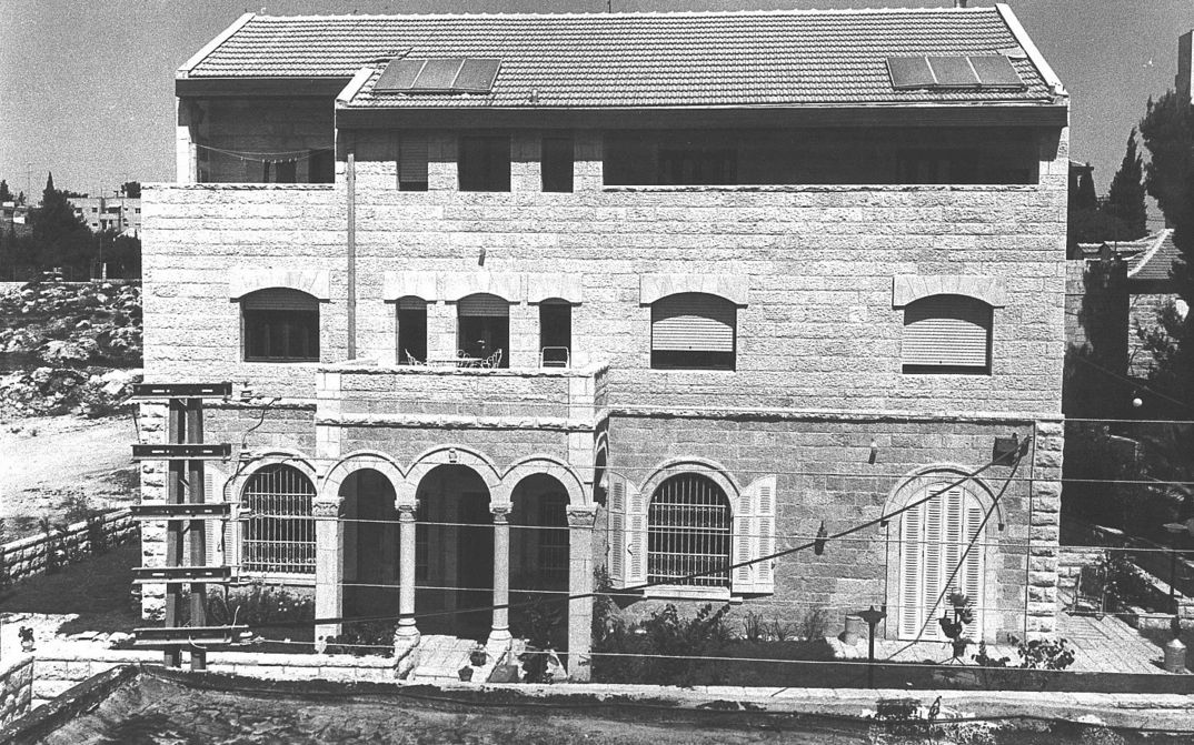 Film still from HOUSE: A building with three floors, a balcony and columns in the entrance area.