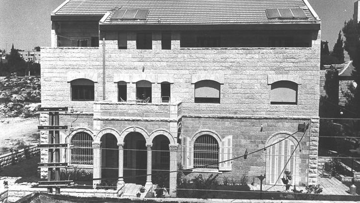 Film still from HOUSE: A building with three floors, a balcony and columns in the entrance area.