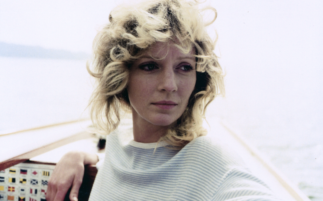 Filmstill aus DIE ALLEINSEGLERIN: Eine junge Frau mit lockigen, blonden Haaren steht am Bug eines Segelbootes.