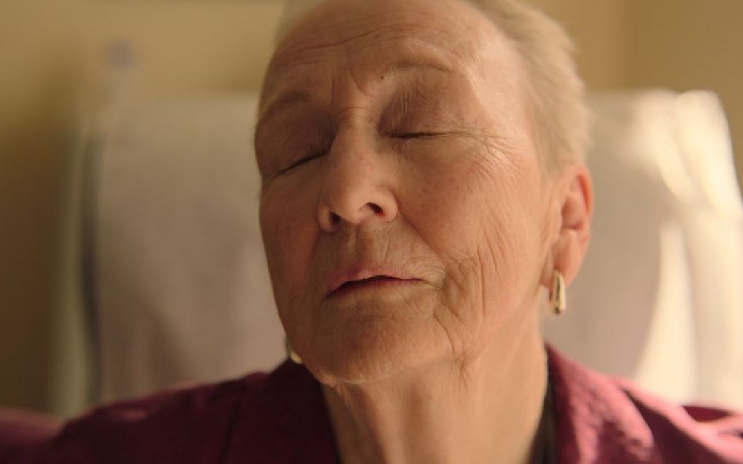 Filmstill aus FAMILIAR TOUCH: Man sieht das Gesicht einer alten Frau. Sie hat die Augen geschlossen und hält ihr Gesicht hoch.