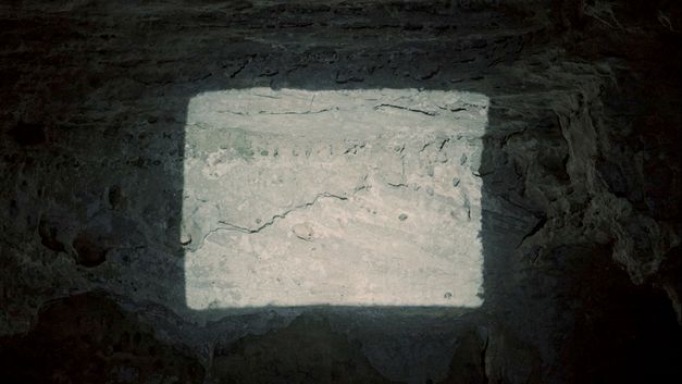 Filmstill aus dem Film „QUEBRANTE“ von Janaina Wagner. Projektion auf eine Höhlenwand.