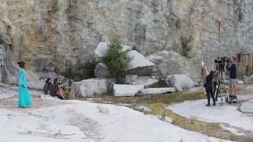 The film crew at work on the set in a rocky landscape