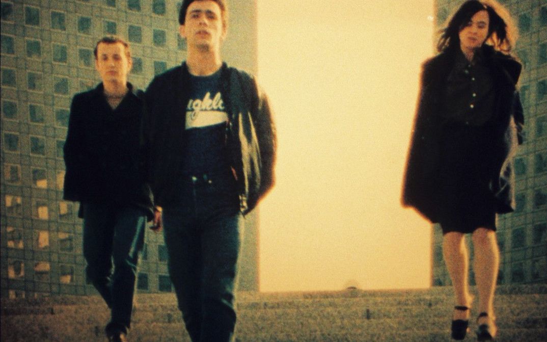Filmstill aus PETIT VOYAGE: Drei jungen Menschen zwischen Hochhäusern.