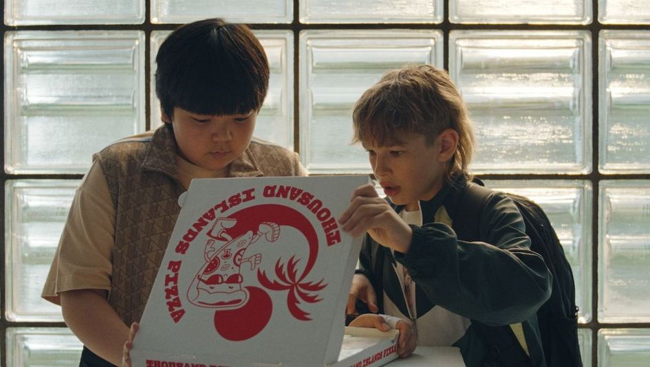 Filmstill aus DER PRANK: Zwei Jungen blicken in einen Pizzakarton.