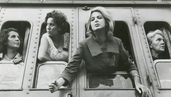 Film still from ESTATE VIOLENTA: Four women are leaning out of the train windows, side by side.
