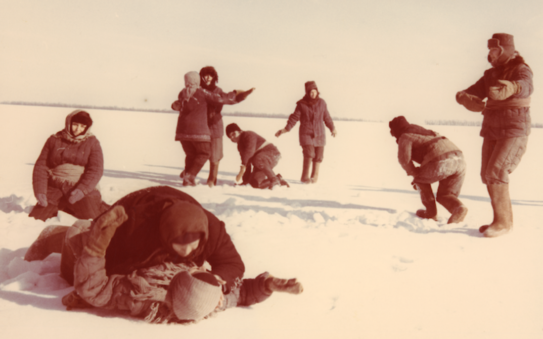 Film still from THE WALTZ ON THE PETSCHORA: A group of women are dancing in the snow, all dressed up.