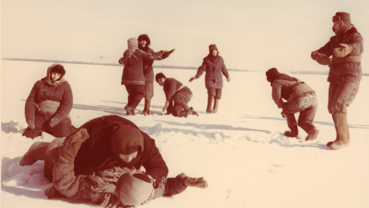 Film still from THE WALTZ ON THE PETSCHORA: A group of women are dancing in the snow, all dressed up.