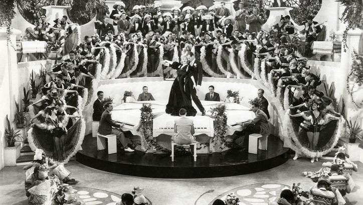 Filmstill aus FLYING DOWN TO RIO. Man sieht eine Massentanzszene, im Zentrum Ginger Rogers und Fred Astaire.