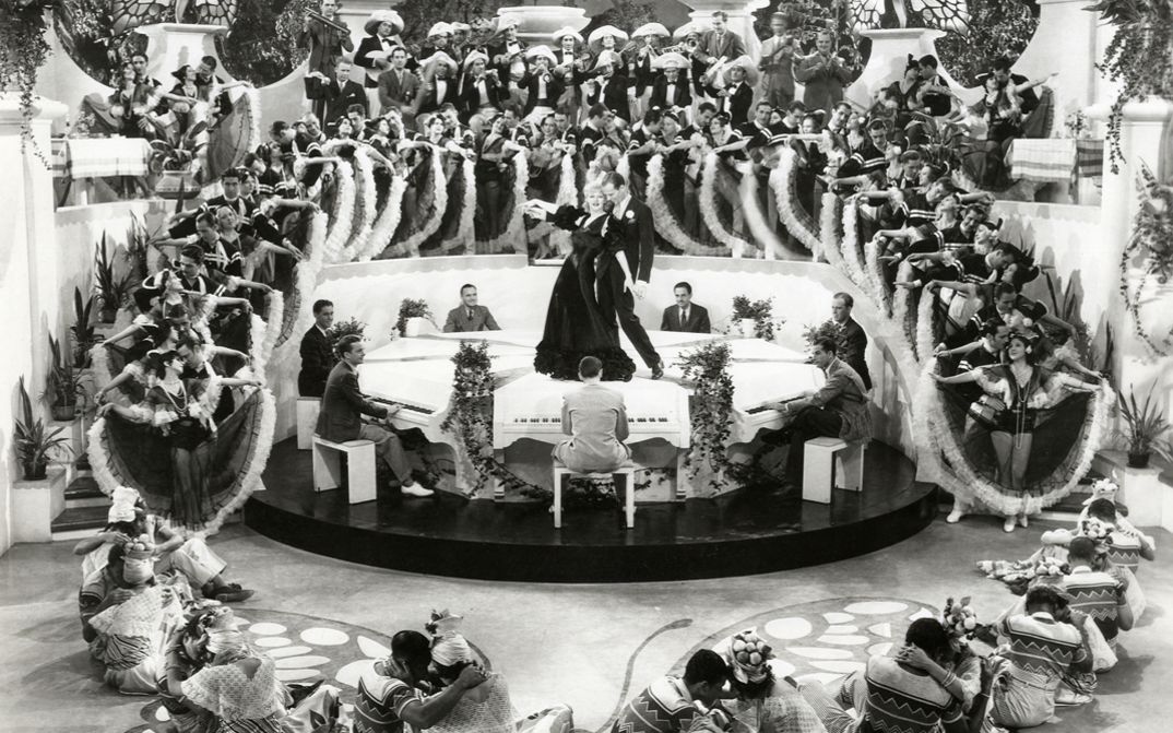 Film still from FLYING DOWN TO RIO. We see a mass dance scene, with Ginger Rogers and Fred Astaire in the center.