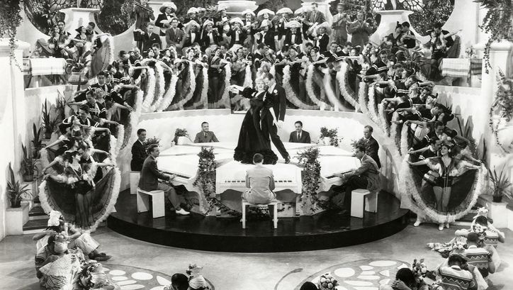 Filmstill aus FLYING DOWN TO RIO. Man sieht eine Massentanzszene, im Zentrum Ginger Rogers und Fred Astaire.