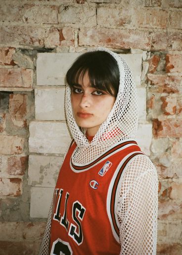 Teenager with white mesh hodie and Bulls t-shirt, wearing heavy eye make-up