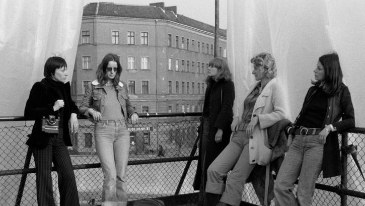 Filmstill aus DIE ALLSEITIG REDUZIERTE PERSÖNLICHKEIT – REDUPERS. Fünf Frauen stehen auf der Terrasse eines Hauses.