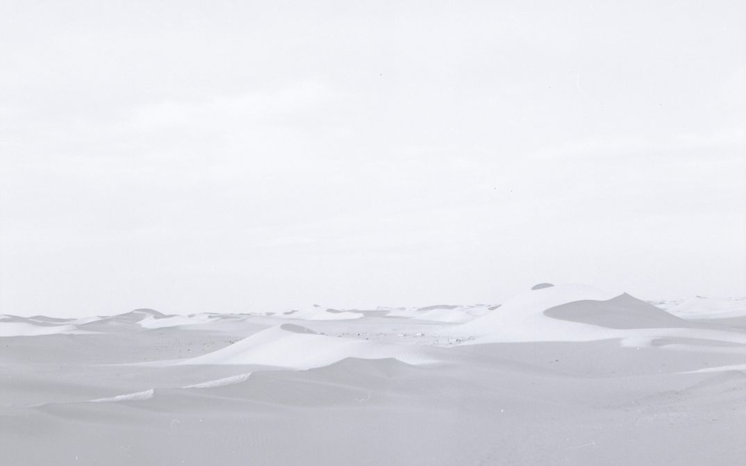 Film still from FATA MORGANA: A desert landscape in delicate black and white color tones.