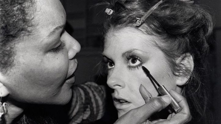 Filmstill aus MODEL. Eine junge Frau wird von einer anderen geschminkt.