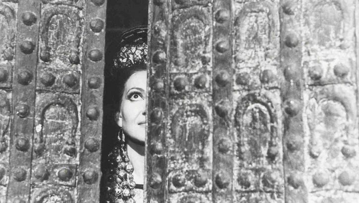 Film still from MEDEA. Maria Callas as Medea looks through a crack in the door.
