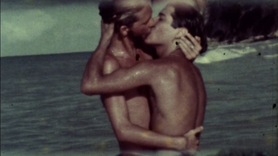 Film still from CLOSES: Two young people embrace and kiss in the sea.