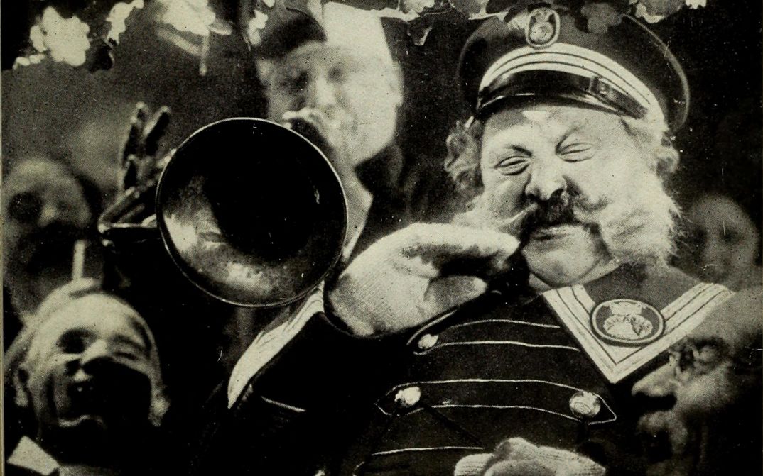 Filmstill aus DER LETZTE MANN: Ein alter Mann mit großem Schnurbart und Uniform steht neben einem Trompeter.