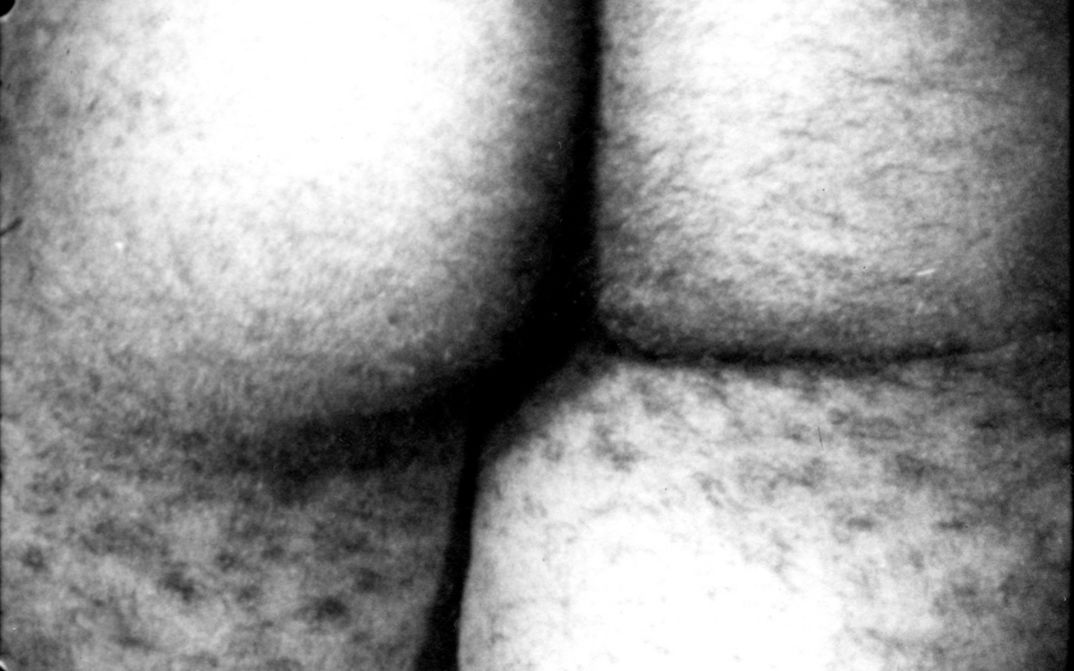 Film Still aus dem Film „Film No. 4 (Bottoms)“ von Yoko Ono. Schwarz-weiß Nahaufnahme eines behaarten Hinterns.