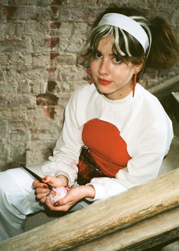 Teenager with white headband and white sweater