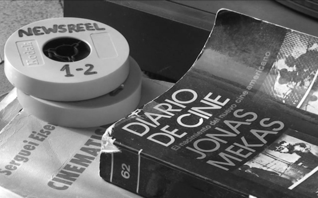 Filmstill aus CORRESPONDENCIA JONAS MEKAS – J.L. GUERÍN: Auf einem Tisch liegen zwei Super-8-Filmdosen und ein Buch mit dem Titel "Diario de Cine. Jonas Mekas"