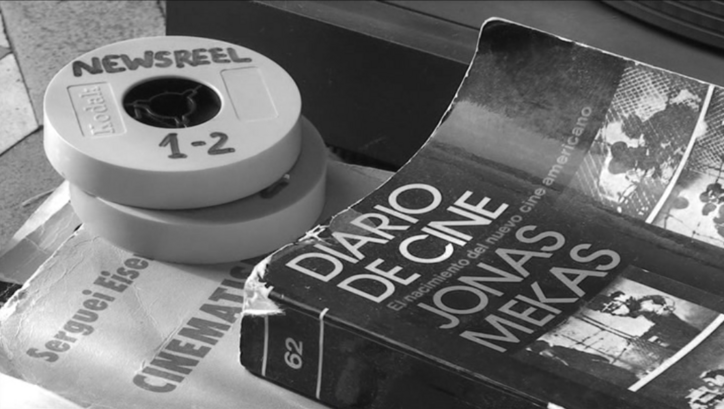 Filmstill aus CORRESPONDENCIA JONAS MEKAS – J.L. GUERÍN: Auf einem Tisch liegen zwei Super-8-Filmdosen und ein Buch mit dem Titel "Diario de Cine. Jonas Mekas"