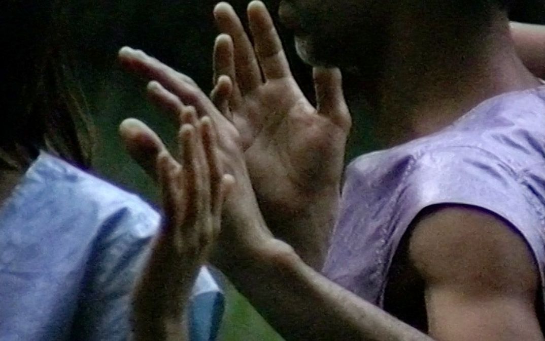 Filmstill aus „Afterwater“ von Dane Komljen. Eine Nahaufnahme der Arme und Oberkörper von zwei Personen.