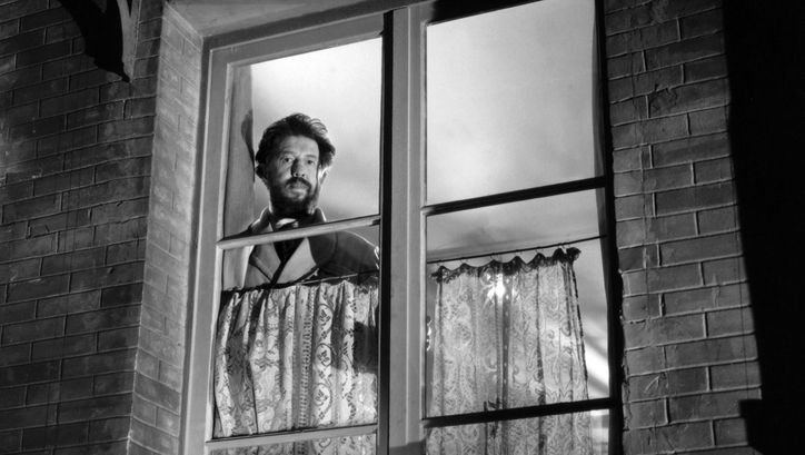 Film still from PANIQUE: A man looks through a window to the outside.