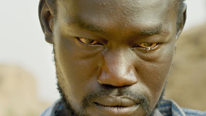 Film still from THE DAM: Close-up of a man with a tear in the corner of his eye.