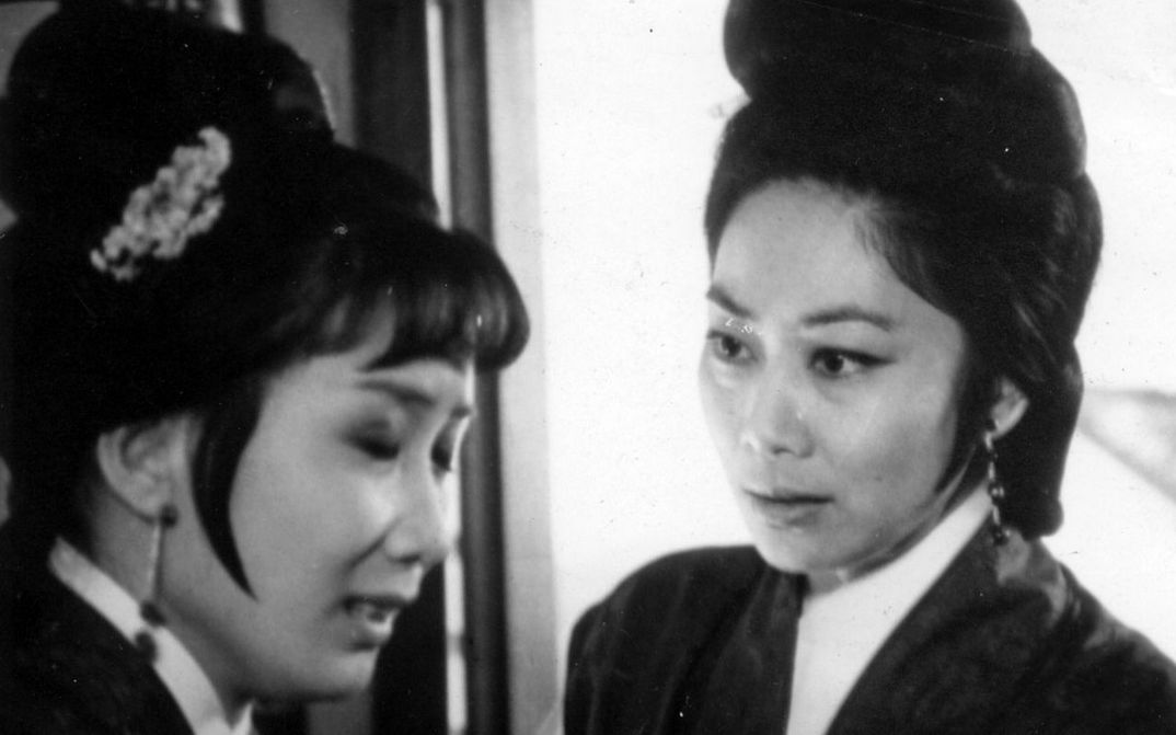 Filmstill aus THE ARCH. Zwei Frauen in historischen Kostümen blicken einander an.