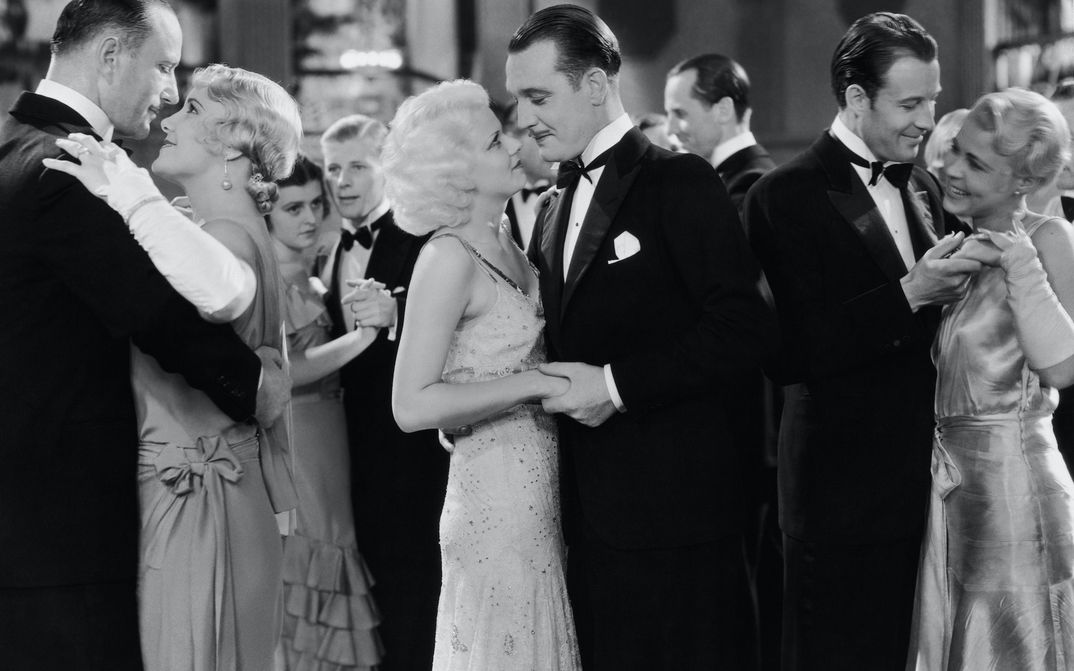 Filmstill aus THREE WISE GIRLS: Mehrere Paare in eleganter Kleidung beim Tanzen.