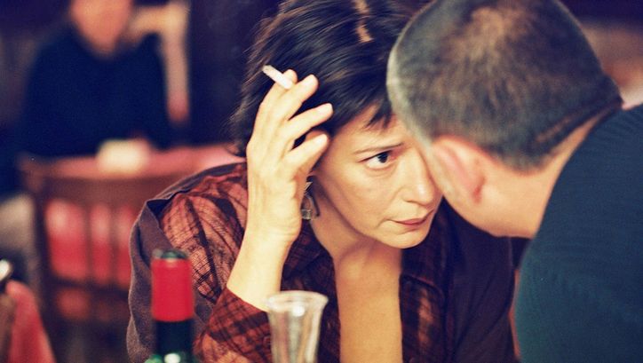 Filmstill aus LA CHOSE PUBLIQUE. Eine Frau und ein Mann in einem Restaurant stecken die Köpfe zusammen.