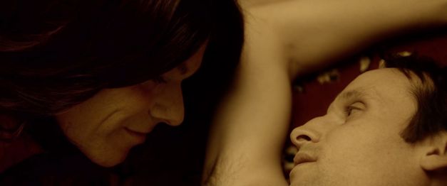 Film still from JANINE ZIEHT AUFS LAND by Jan Eilhardt. The image shows a close-up of two people intimately gazing at each other.