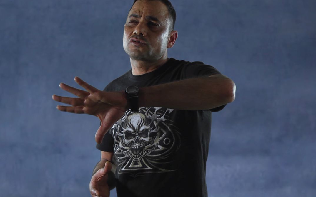 Filmstill from NON É SOGNO. A man performs in front of a neutral background.