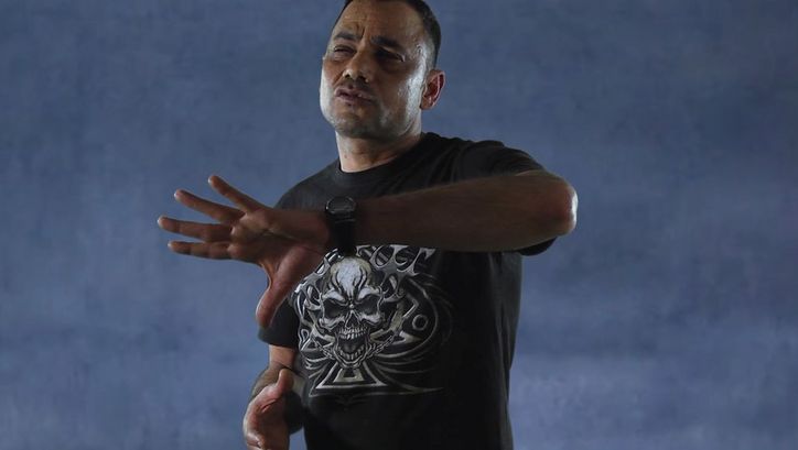 Filmstill from NON É SOGNO. A man performs in front of a neutral background.