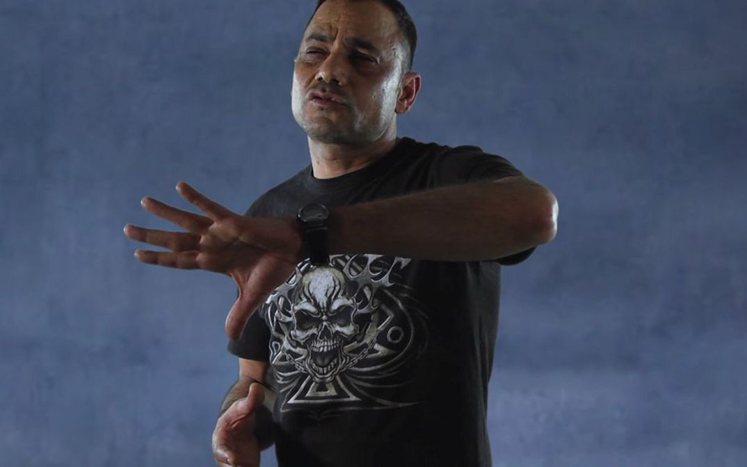 Filmstill from NON É SOGNO. A man performs in front of a neutral background.