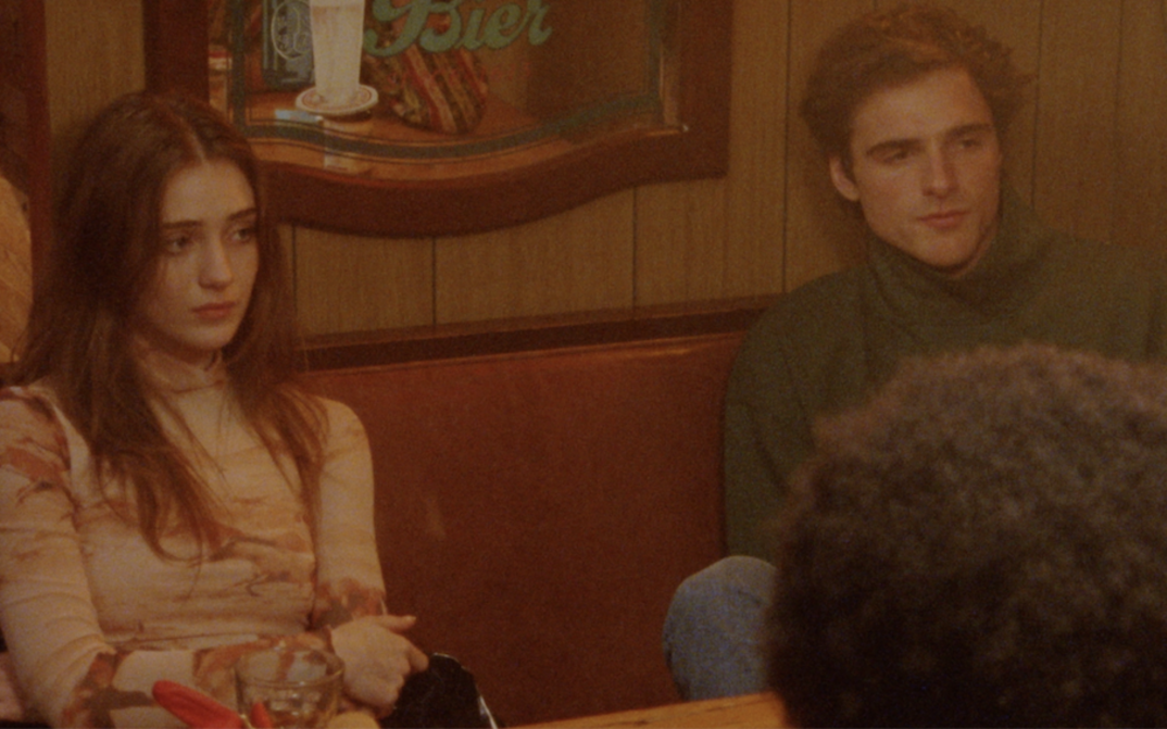 Film still from THE SWEET EAST: A group of young people are sitting in a pub.