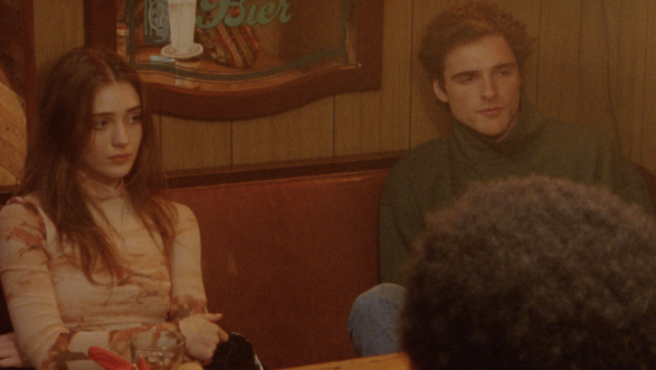 Film still from THE SWEET EAST: A group of young people are sitting in a pub.