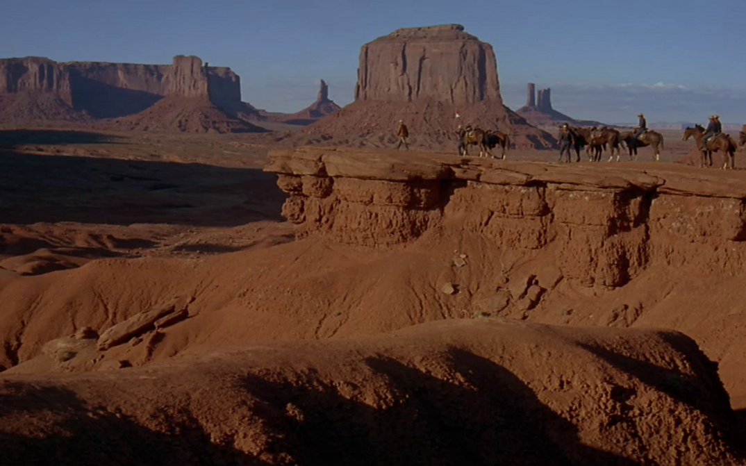 Filmstill aus CHEYENNE AUTUMN: Eine Gruppe von Reitern in der Wüste des Monument Valley.