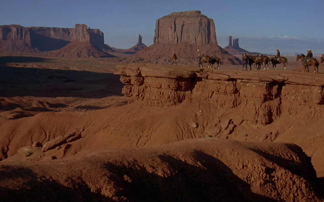 Film still from CHEYENNE AUTUMN: A group of horsemen in the desert of Monument Valley.