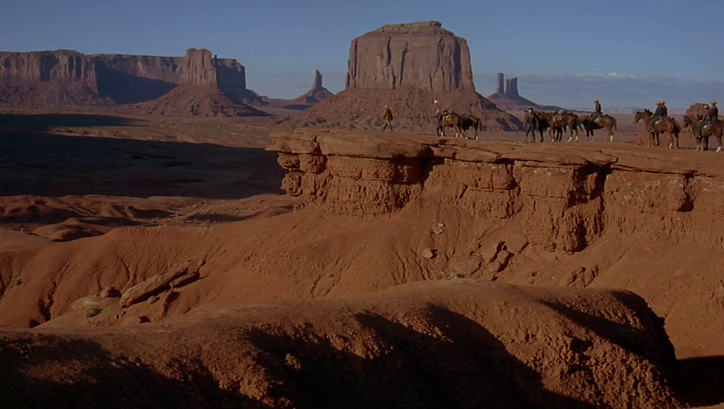 Filmstill aus CHEYENNE AUTUMN: Eine Gruppe von Reitern in der Wüste des Monument Valley.