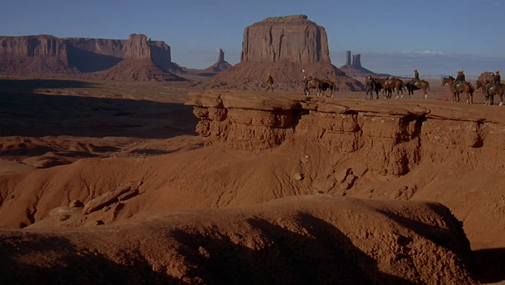 Filmstill aus CHEYENNE AUTUMN: Eine Gruppe von Reitern in der Wüste des Monument Valley.
