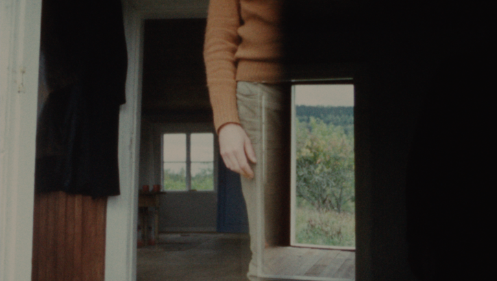 Filmstill aus KASKARA: Man sieht übereinandergelegte Bilder; das Innere eines Hauses, den Körper einer Person ohne den Kopf.