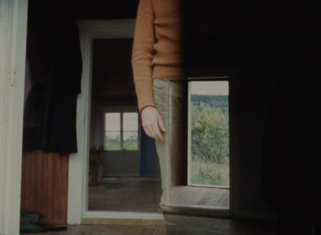 Filmstill aus KASKARA: Man sieht übereinandergelegte Bilder; das Innere eines Hauses, den Körper einer Person ohne den Kopf.