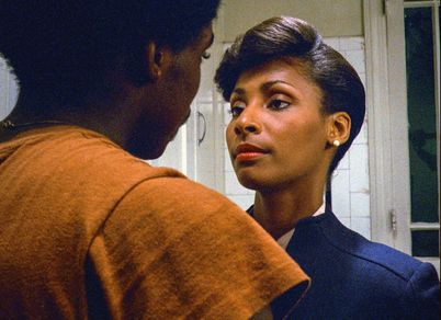 Eine Frau und ein Mann stehen sich in einer Küche gegenüber und schauen sich an.