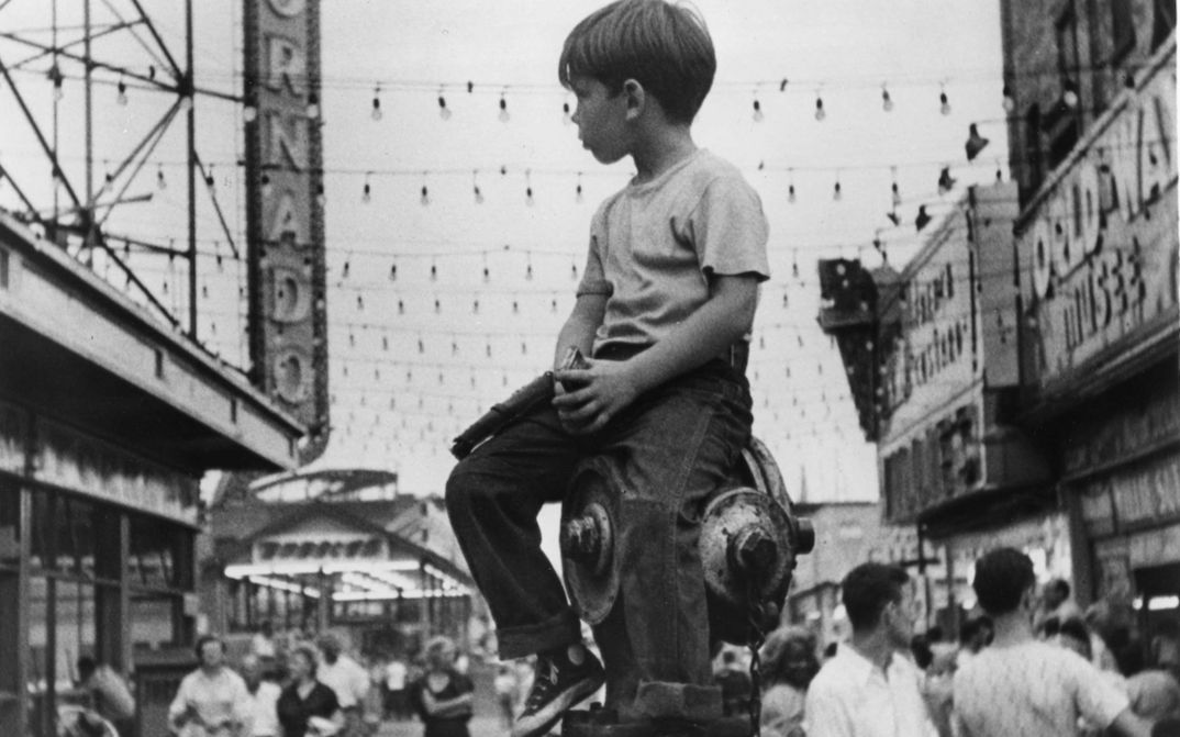 Filmstill aus THE LITTLE FUGITIVE: Ein kleiner Junge sitzt in Coney Island auf einem Hydranten.